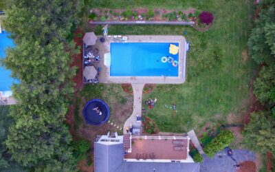 A large above ground pool with a wooden deck surround in a family backyard
