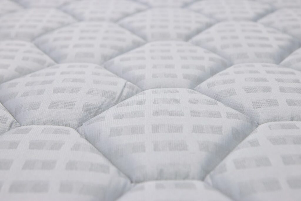 Crisp white cooling sheets on a neatly made bed in a bright modern bedroom