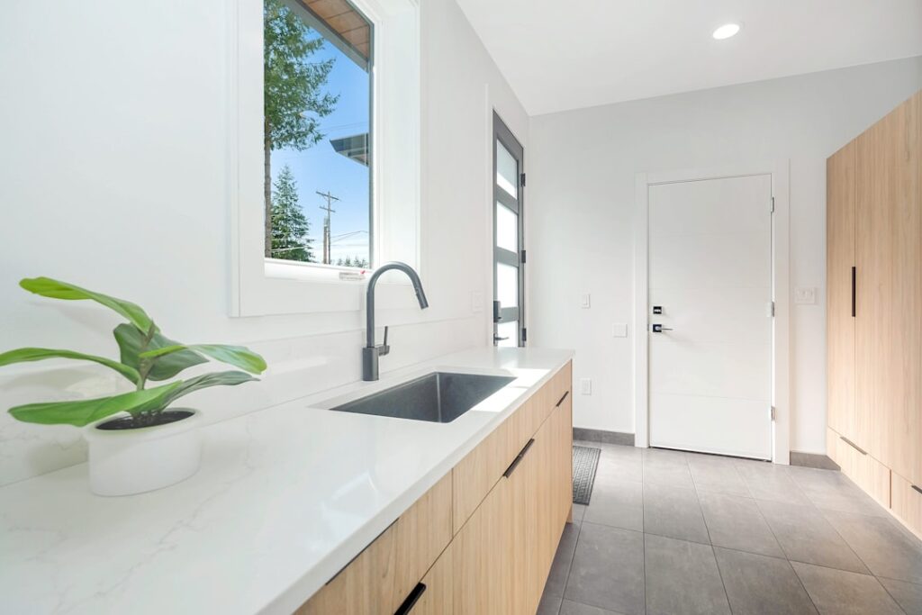 Clean modern laundry room with white cabinets and durable flooring