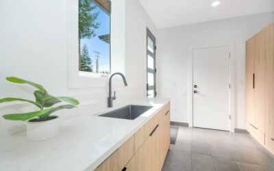 Clean modern laundry room with white cabinets and durable flooring