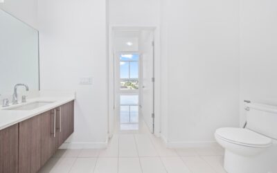 Sparkling clean white toilet in a modern bathroom with white tile floor and fresh towels