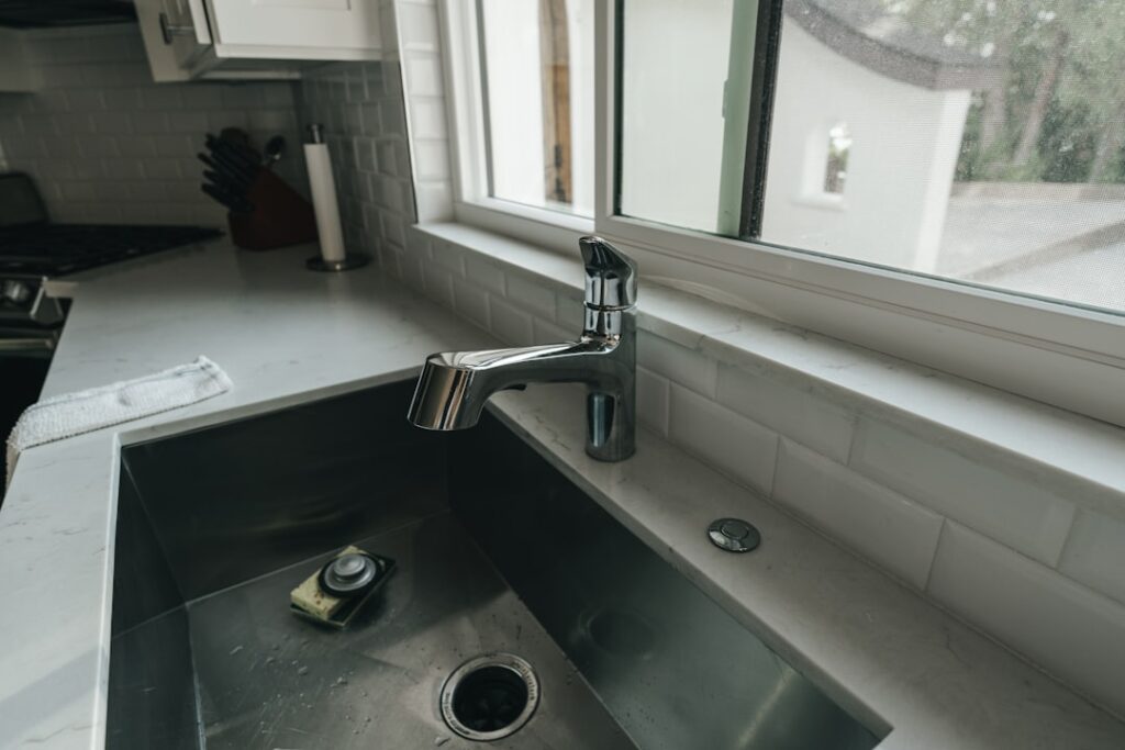 Under sink water filtration system installed beneath a modern kitchen cabinet