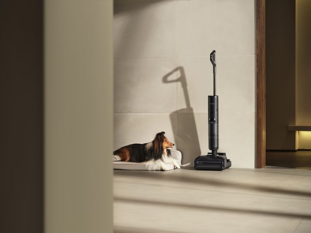 Upright vacuum cleaning golden retriever fur from a light hardwood floor