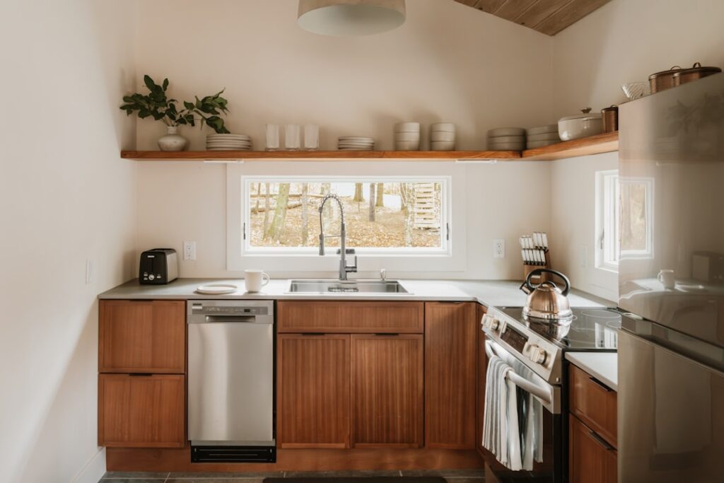 Neatly organized kitchen cabinet with patterned shelf liner protecting white shelves