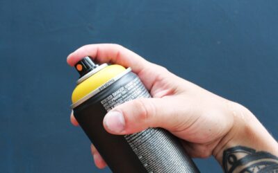 Spray bottle with homemade carpet cleaning solution next to a brush on carpet