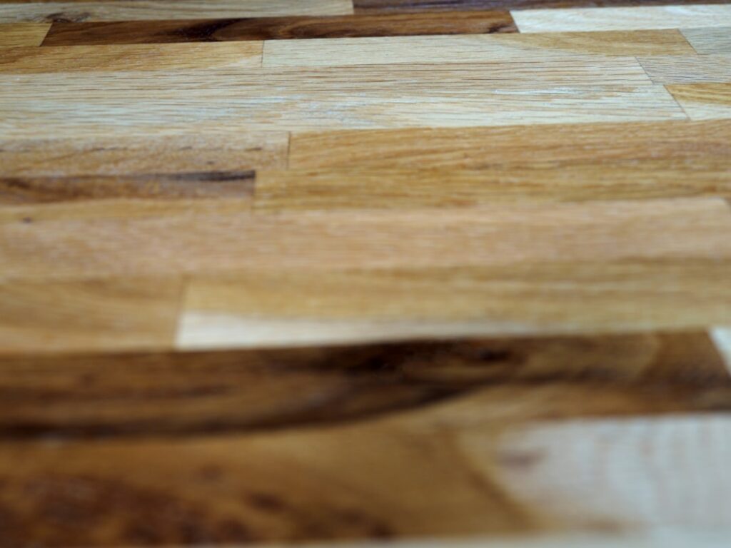 Cross-section of engineered wood showing multiple plywood layers beneath oak veneer
