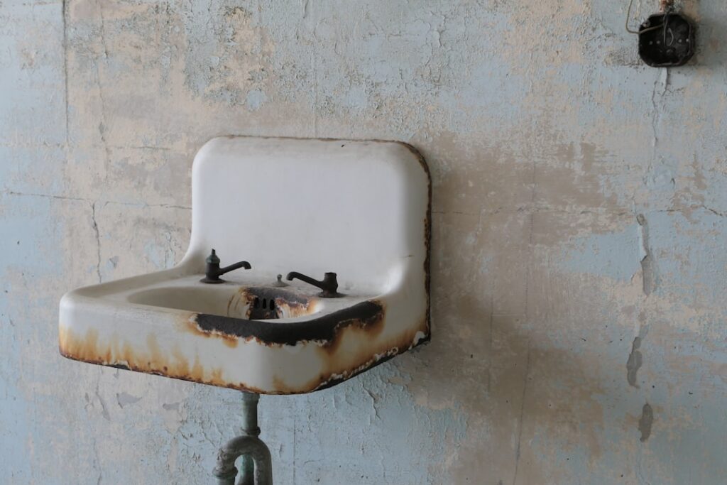 Rustic farmhouse bathroom with white shiplap walls a wood vanity and vintage fixtures