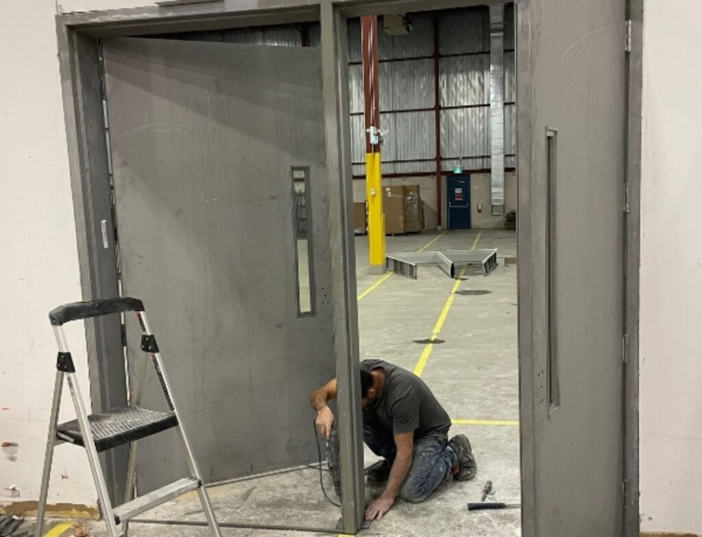 Professional flooring installer measuring and cutting hardwood planks on site