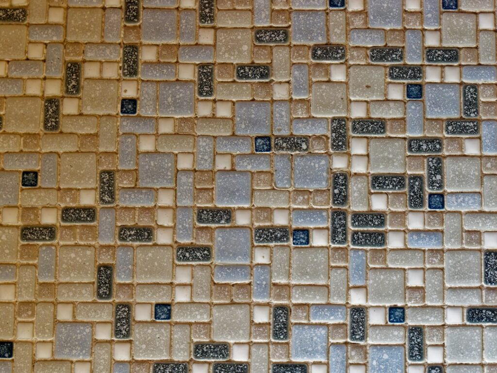 Assorted flooring material samples including hardwood, tile, and stone arranged side by side