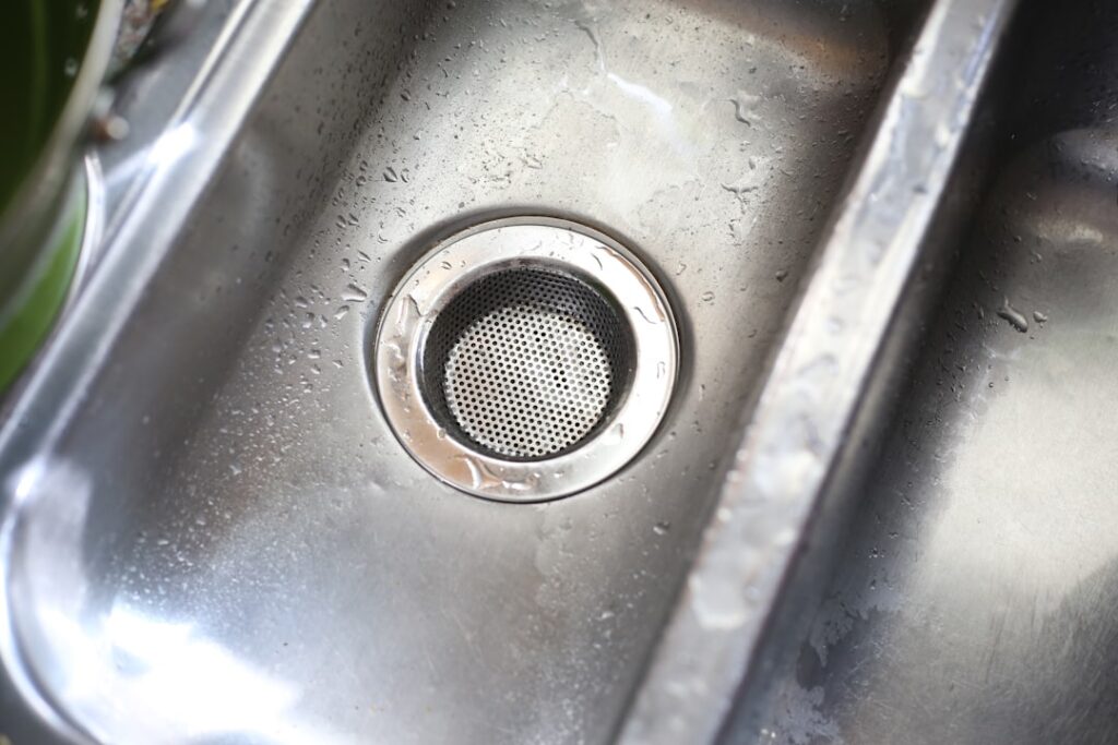 Under-sink view showing a garbage disposal unit with visible leak at the bottom