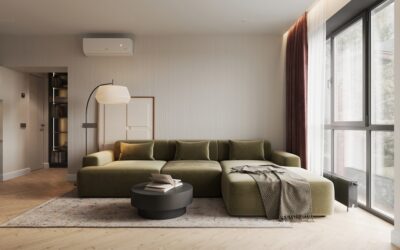 A deep green velvet sofa in a bright living room with light hardwood flooring and neutral decor