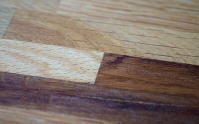 Close-up of a hardwood floor scratch being repaired with a wood filler touch-up