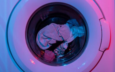 Glass jars of homemade laundry detergent powder alongside natural ingredients like borax and washing soda