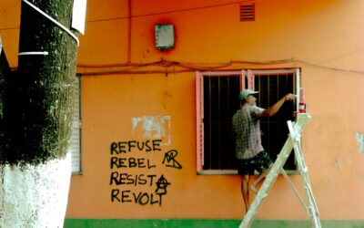 Open paint cans with rollers and brushes arranged on a drop cloth during home renovation