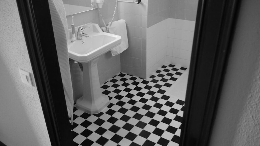 Person mopping clean porcelain tile floor in a bright kitchen