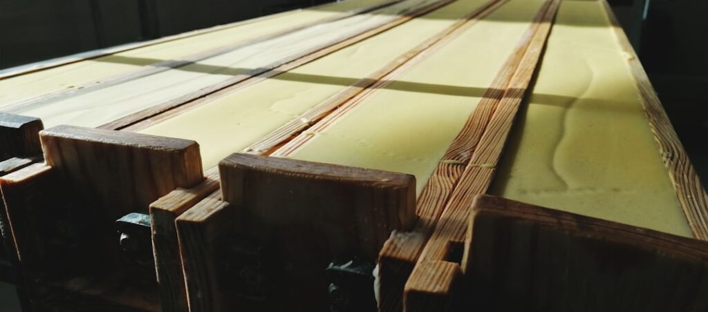 Person polishing a dark wood dining table with a soft cloth to restore its shine
