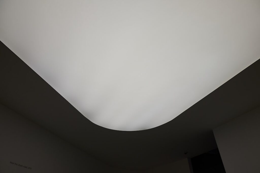 Freshly smoothed ceiling in a bright renovated room after popcorn texture removal