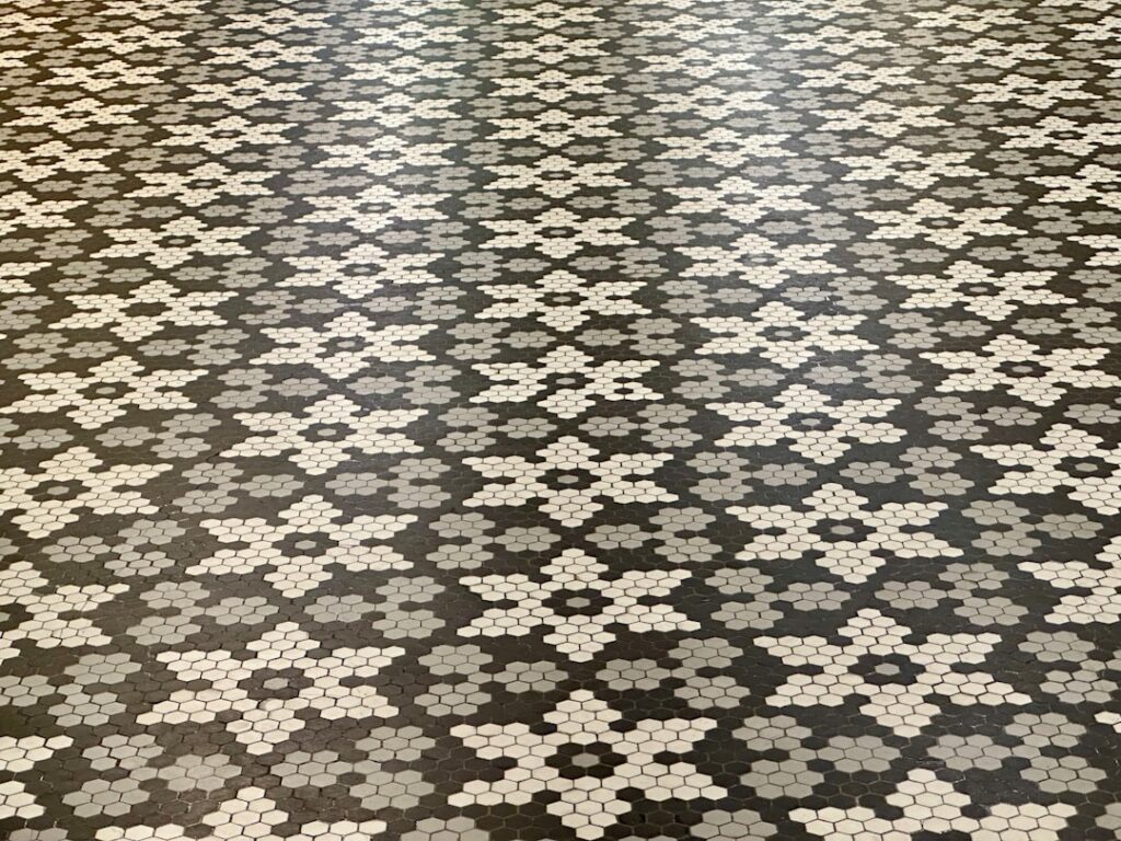 Removing ceramic floor tiles with a chisel and hammer