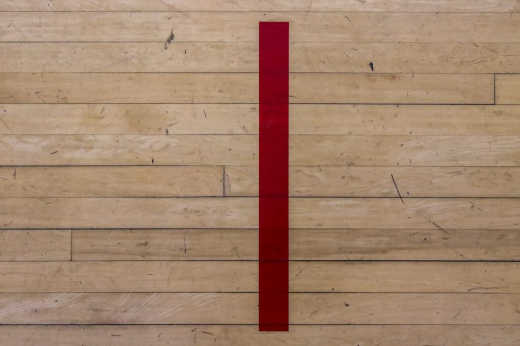 Person measuring a room with a tape measure for laminate flooring installation