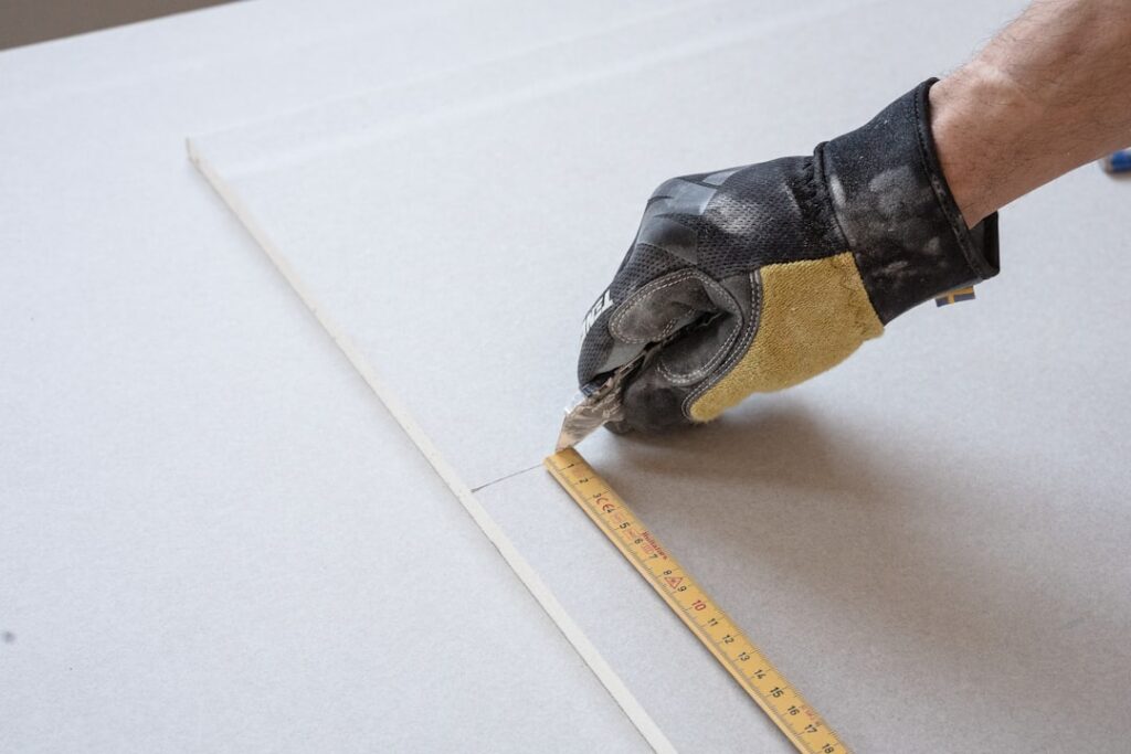 Person laying laminate flooring planks in a room
