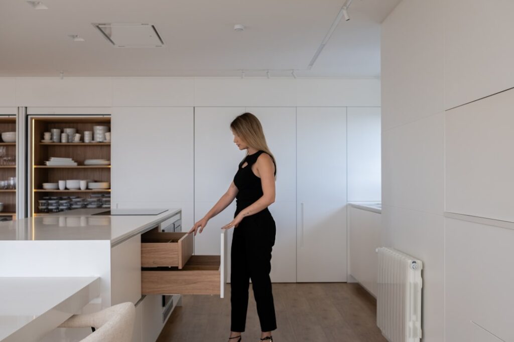 Roll of sheet vinyl flooring being unrolled for installation in a kitchen
