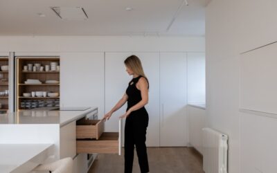 Roll of sheet vinyl flooring being unrolled for installation in a kitchen