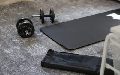 Black rubber gym flooring rolls installed in a home gym with weight equipment