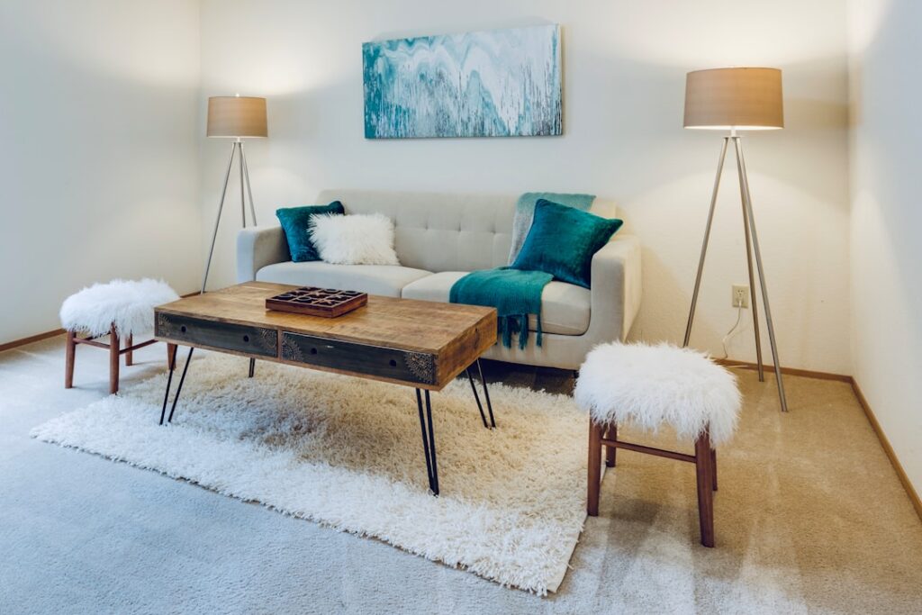 Patterned area rug layered over neutral wall-to-wall carpet in a cozy living room