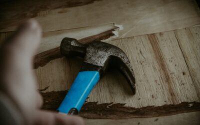 Worker using a floor scraper to remove old ceramic tile from a concrete subfloor