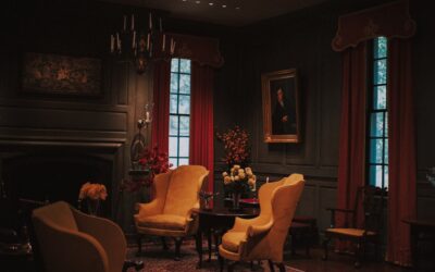 Rich emerald green velvet curtains hanging in an elegant living room with warm lighting