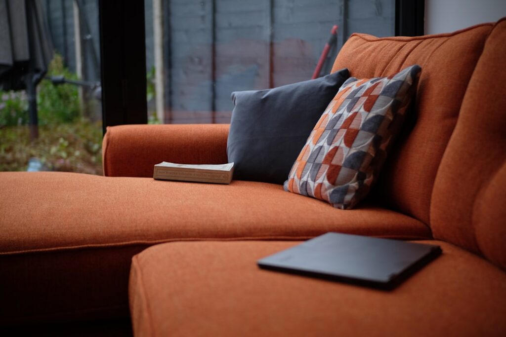 A cozy living room with warm-toned hardwood flooring and terracotta accent wall