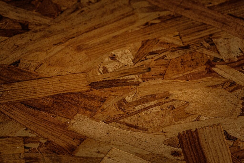 Applying wood filler to a gouge in an oak hardwood floor with a putty knife