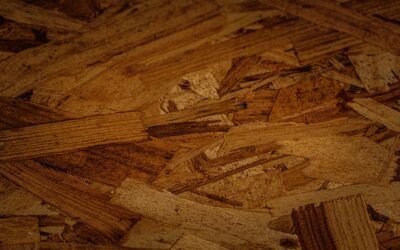 Applying wood filler to a gouge in an oak hardwood floor with a putty knife