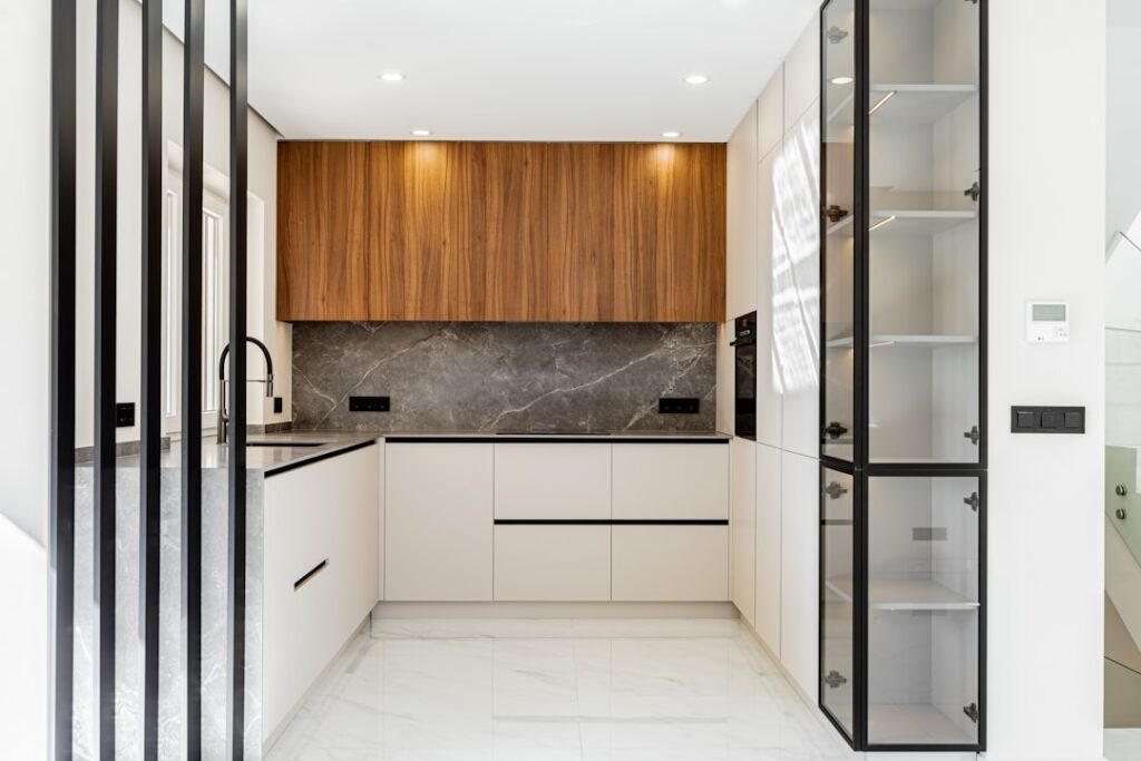Kitchen with white cabinets and a marble herringbone backsplash