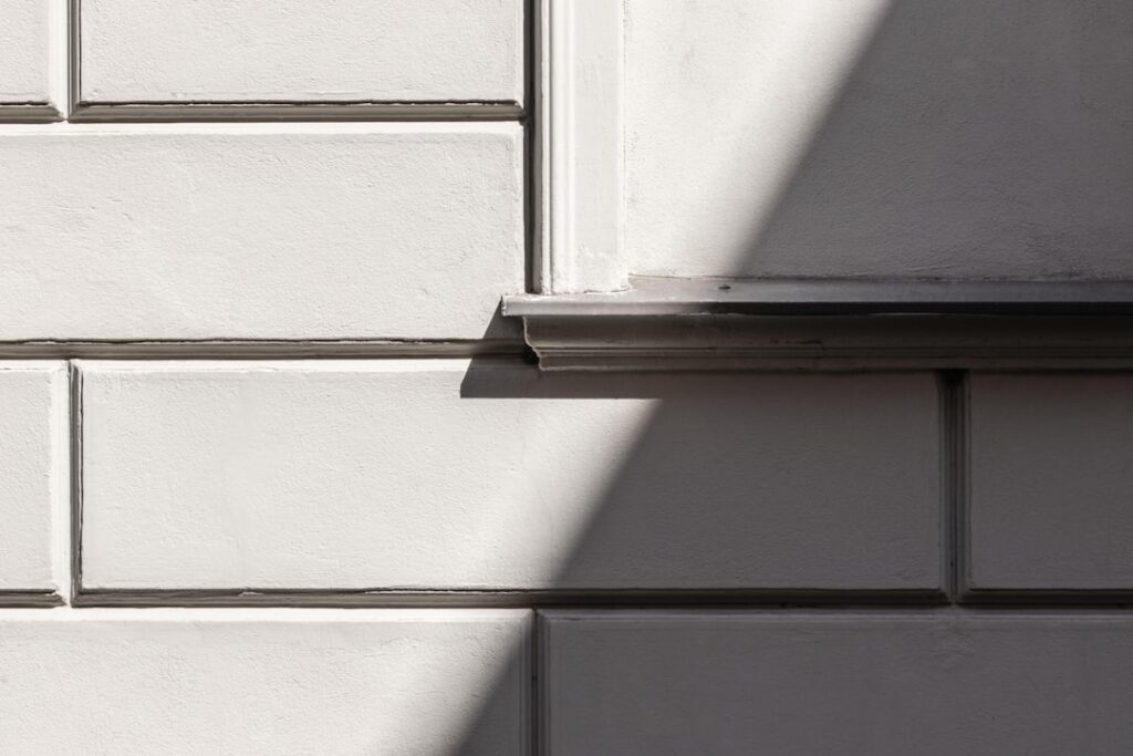 Close-up of metal Schluter trim finishing a kitchen backsplash edge
