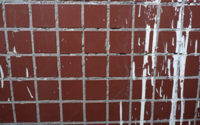 Applying grout sealer to shower tile grout lines with an applicator bottle