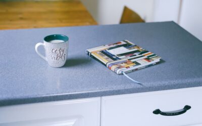 homeowner applying paint to laminate kitchen countertops with a foam roller